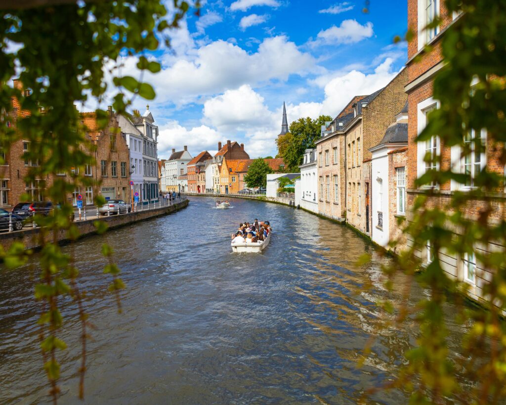 People Sailing on Boat in City Canal